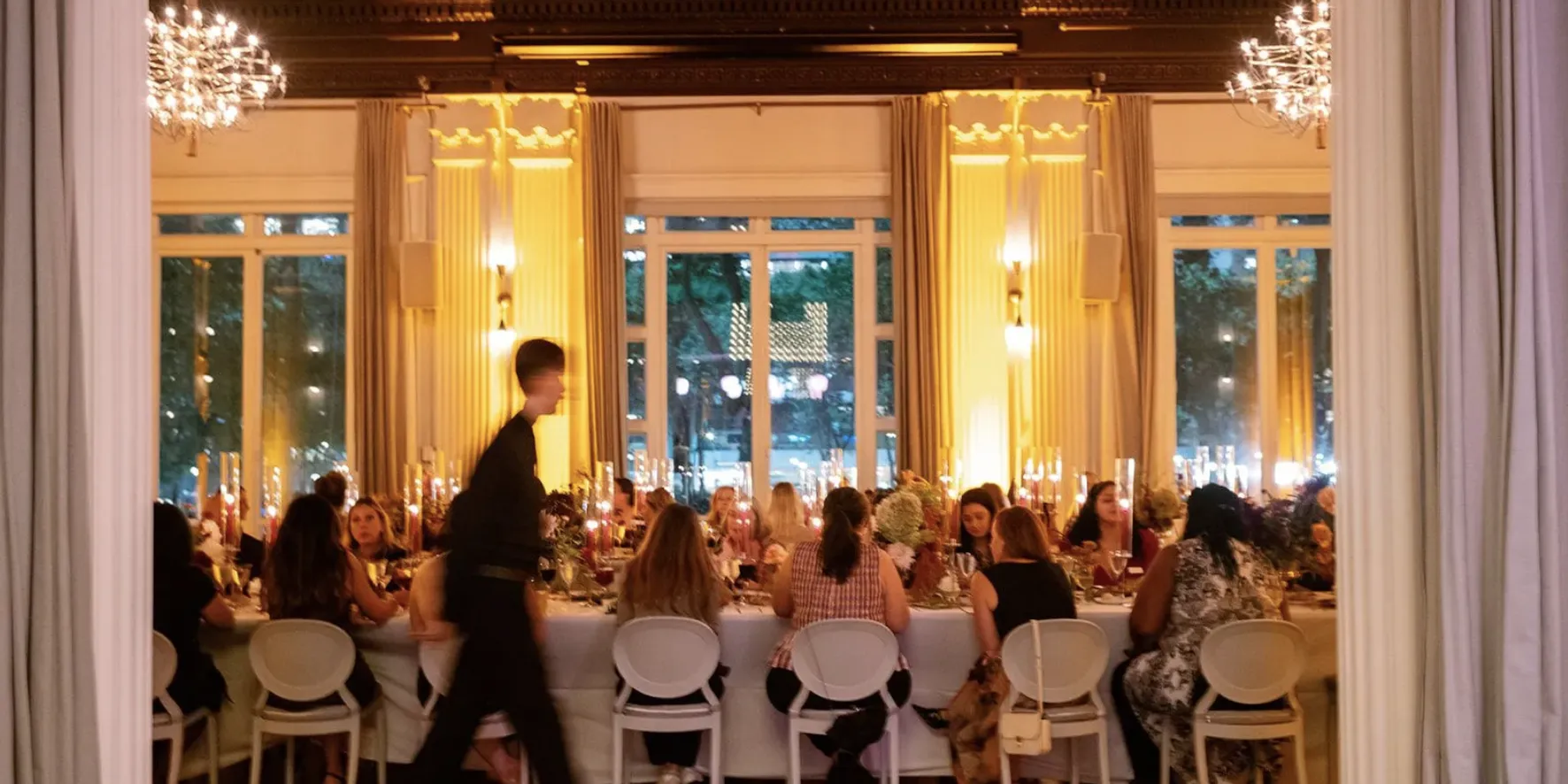 Long banquet table set for a formal dinner under chandeliers