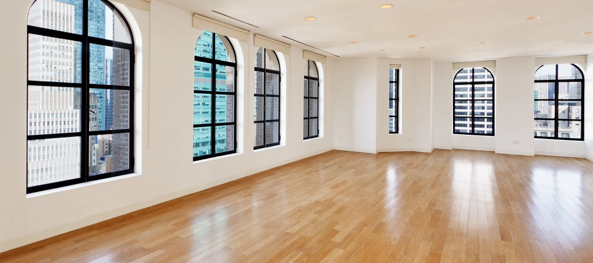 The Loft event space with arched windows overlooking the Midtown skyline